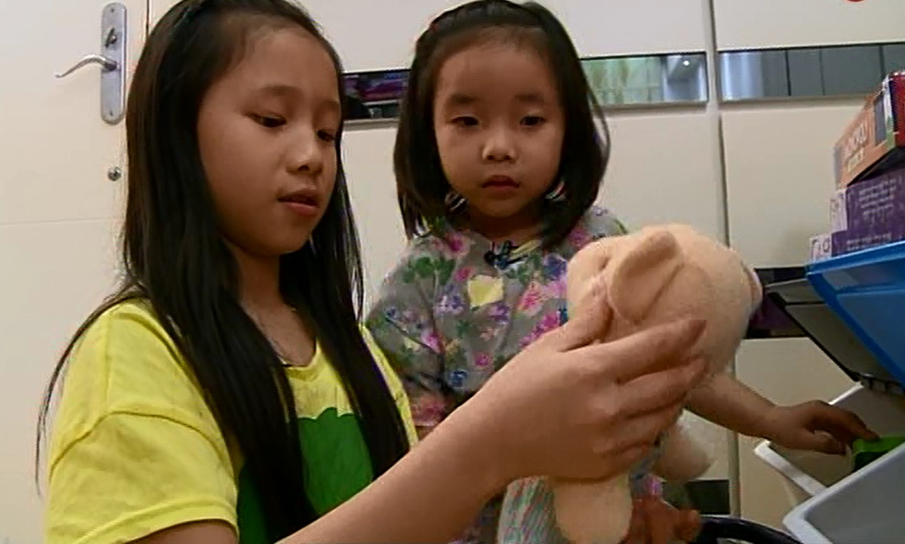 柏瑜及妹妹栢晞于比赛前，在家中商量捐哪些玩具到玩具银行。